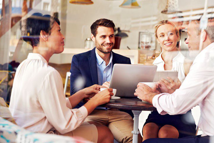 Blog-Post-Pic-ClearGoalsWebsiteSuccess-720×480-1 group of adults sitting in a coffee shop discussing clear goals to set for their website