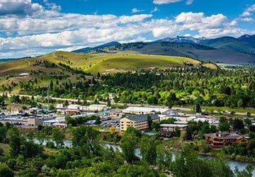 view of green and lush downtown Missoula, Montana from the top of a hill during the summertime